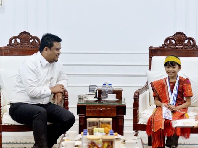 Gubernur Sumatera Utara Muhammad Bobby Afif Nasution memberikan hadiah rumah dan beasiswa pendidikan kepada Caroline Cicilia Nababan, siswi SD Negeri 18 Rantau Selatan, Kabupaten Labuhanbatu, yang meraih medali emas pada ajang Asia Science & Mathematics Competition (ASMC) Global Round 2026 di Kuala Lumpur, Malaysia.