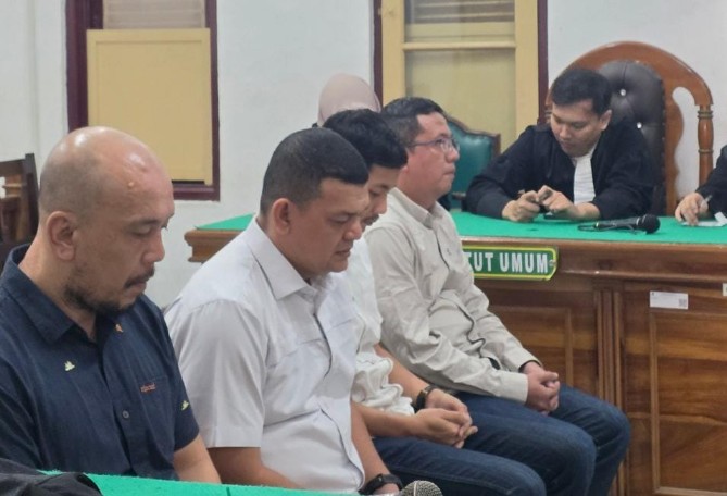 Erwin Saleh (dua dari kiri) saat mendengarkan vonis majelis hakim. Foto; IST